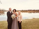 bride and groom with Melissa in front of lake